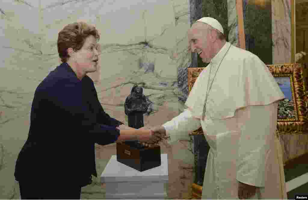 O Papa cumprimenta a presidente brasileira Dilma Rousseff após receber uma pintura do Rio de Janeiro durante uma cerimônia de boas-vindas na segunda-feira.