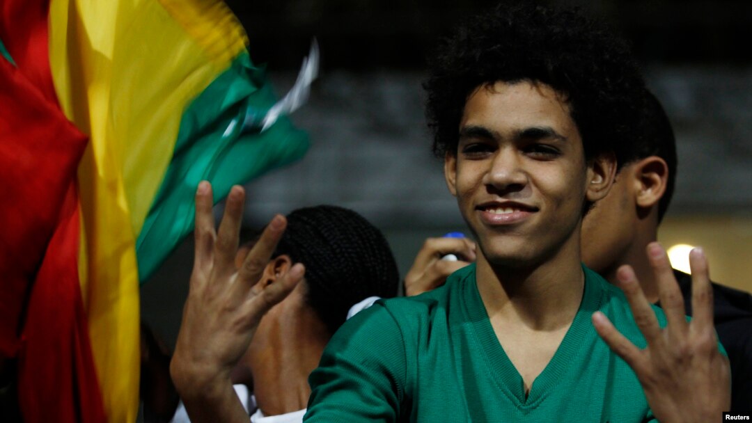 A fan gestures with a Rabaa sign after the 2014 World Cup qualifying second leg playoff soccer match between Ghana and Egypt in Cairo, Nov. 19, 2013. 