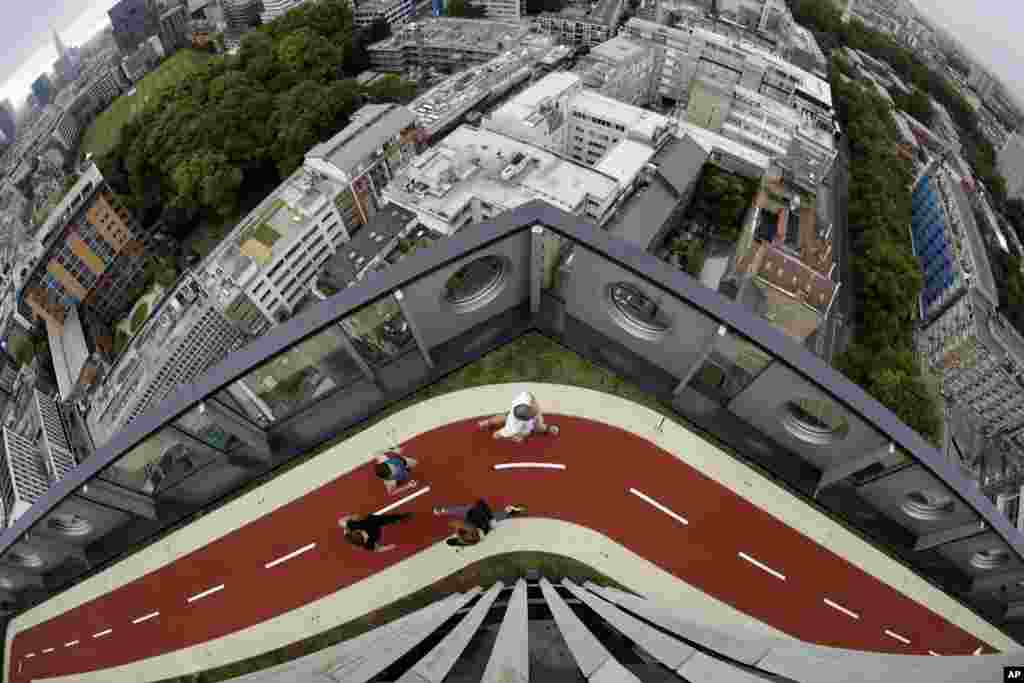 People run along a stretch of the new 150-meter rooftop running track, as seen from the roof terrace of the recently redeveloped 16-story office tower of the White Collar Factory development in London. The new track is the highest one in London.