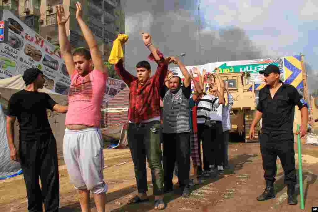 As forças de segurança egípcias detêm manifestantes no acampamento no leste do distrito Cidade Nasr, Cairo.