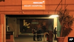 Police officers stand outside the main entrance of the Mediclinic Heart Hospital where former South African President Nelson Mandela is being treated in Pretoria, South Africa Sunday, Jun. 23, 2013. 