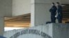 FILE - Security personnel man an observation post on the roof to the entrance of the Walter Reed Army Medical Center in Bethesda, Maryland.