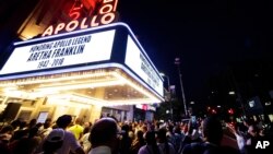 People gather at a makeshift memorial at the nameplate for singer Aretha Franklin outside the Apollo Theater, Aug. 16, 2018, in New York. Franklin died Thursday in her home in Detroit at age 76 from pancreatic cancer.