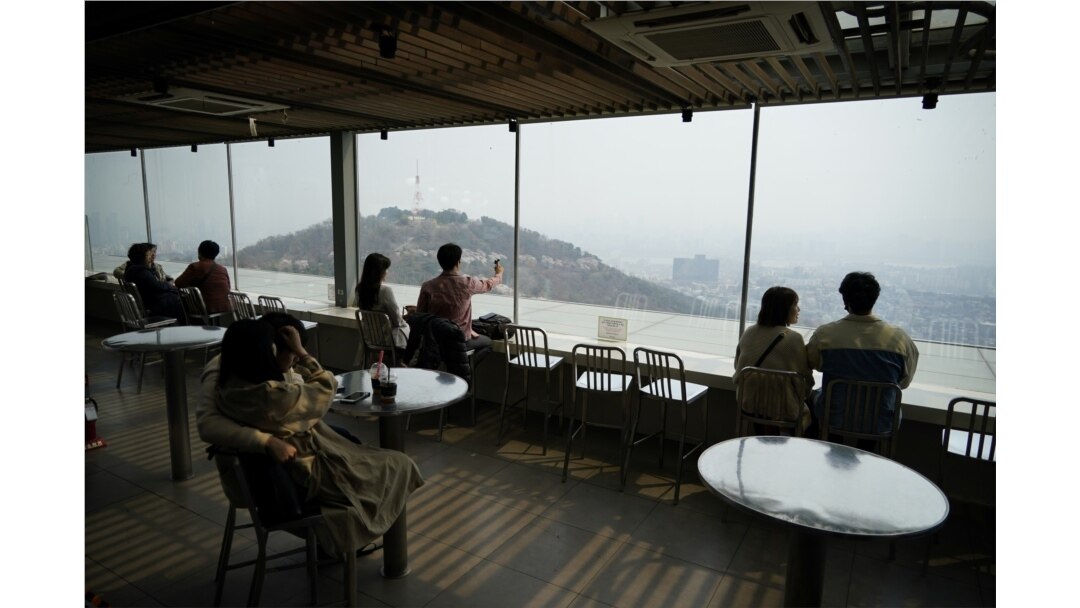 Couples enjoy the view while practicing social distancing during the global spread of the coronavirus disease (COVID-19), at an observatory near "N Seoul Tower" located atop Mt. Namsan in Seoul, South Korea, April 7, 2020.