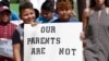 FILE - Children of mainly Latino immigrant parents hold signs in support of them and those individuals picked up during an immigration raid, during a protest march to the Madison County Courthouse in Canton, Miss., Aug. 11, 2019.