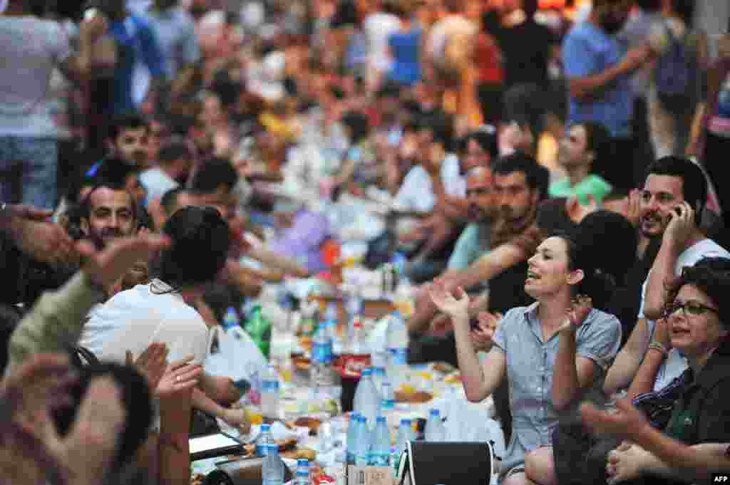 Turkish anti-goverment protesters chant slogans before breaking their first day of fasting for the Muslim holy month of Ramadan on Istiklal Street, the main shopping corridor in Istanbul, July 9, 2013.