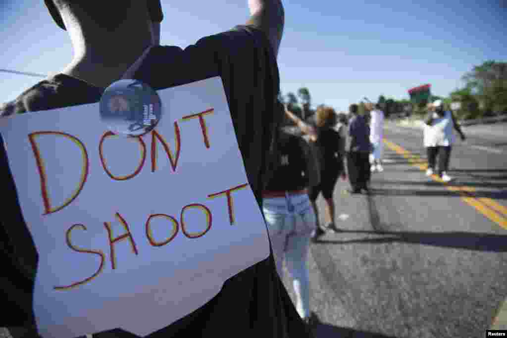 Um manifestante usa um cartaz nas costas que diz "Não dispare", durante a manifestação contra a morte a tiro do jovem Michael Brown, em Ferguson, Missouri, Ago. 13, 2014.