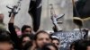 A man with a weapon holds an Islamist flag during a protest against Syria's President Bashar al-Assad in Bustan al-Qasr district in Aleppo, March 22, 2013. The flag reads, "There is no God but Allah and Mohammad is the messenger of Allah" REUTERS/Giath Ta