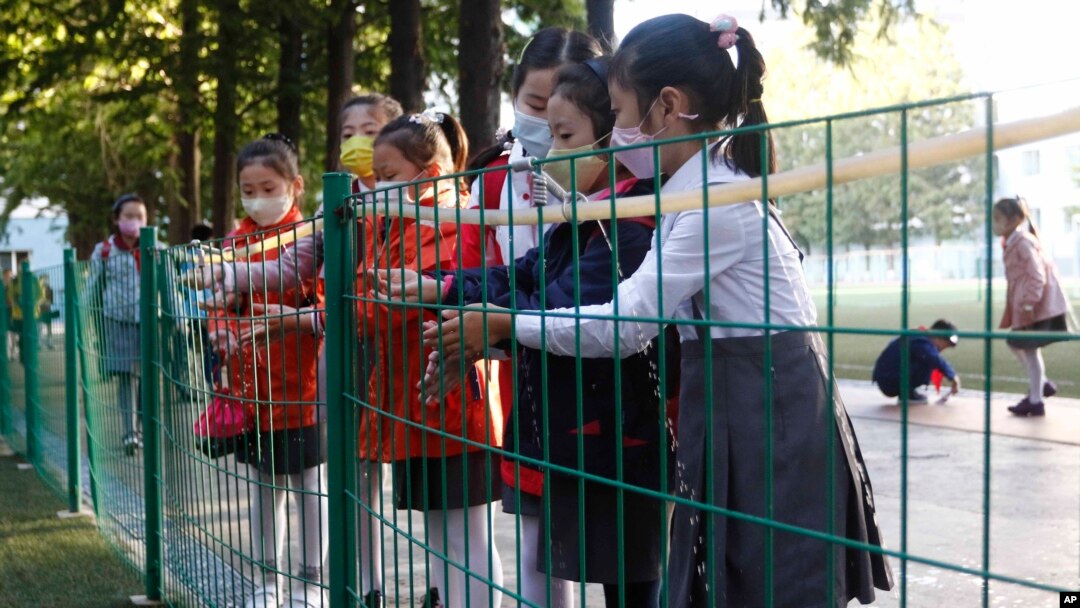 School children wash their hands to help curb the spread of the coronavirus before entering Kim Song Ju Primary School in Central District in Pyongyang, North Korea, Oct. 13, 2021.