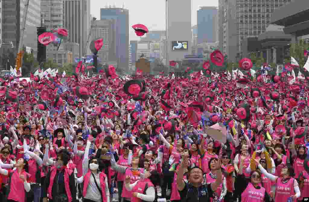 Members of the Korean Confederation of Trade Union toss their hats into the air during a rally against the government's labor policy in Seoul, South Korea. Thousands of workers rallied to demand better working conditions and urge companies to stop using temporary employees.