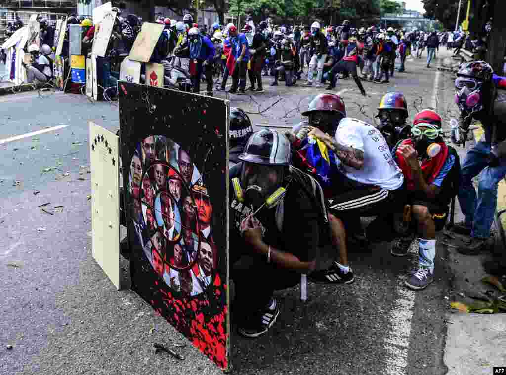 Opposition activists hide behind shields as they clash with the police during a march towards the Supreme Court of Justice (TSJ) in a protest against President Maduro and his call for Constituent Assembly in Caracas, Venezuela, July 22, 2017.