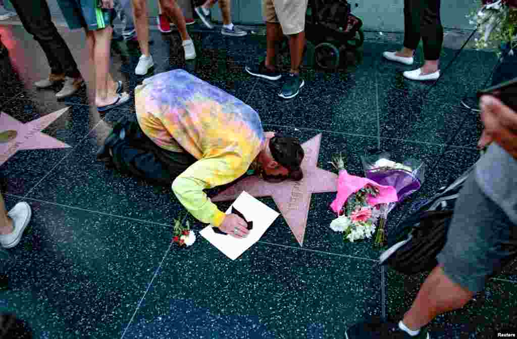 J.R. Kail kisses a makeshift memorial for late country music entertainer Glen Campbell around his star on the Hollywood Walk of Fame in Los Angeles, California, Aug. 8, 2017.