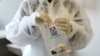 FILE - A health worker holds a COVID-19 sample collection kit of a vaccine trial volunteer, after a test for the coronavirus disease, at the Wits RHI Shandukani Research Centre in Johannesburg, South Africa, Aug. 27, 2020.