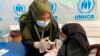 FILE - A Rohingya refugee gets vaccinated against COVID-19 in Cox's Bazar, Bangladesh, Aug.10, 2021.