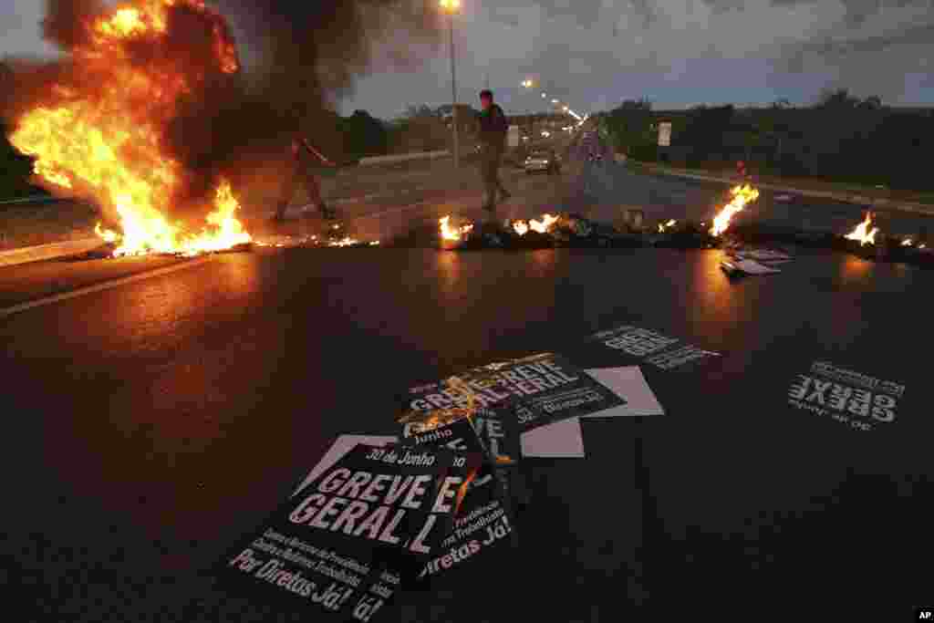 Military policemen clear a flaming barricade on an access highway to Brasilia, Brazil. Unions representing transportation workers and others called for a shutdown to protest proposals in Congress to loosen labor rules and trim pension benefits in Latin America's largest nation.
