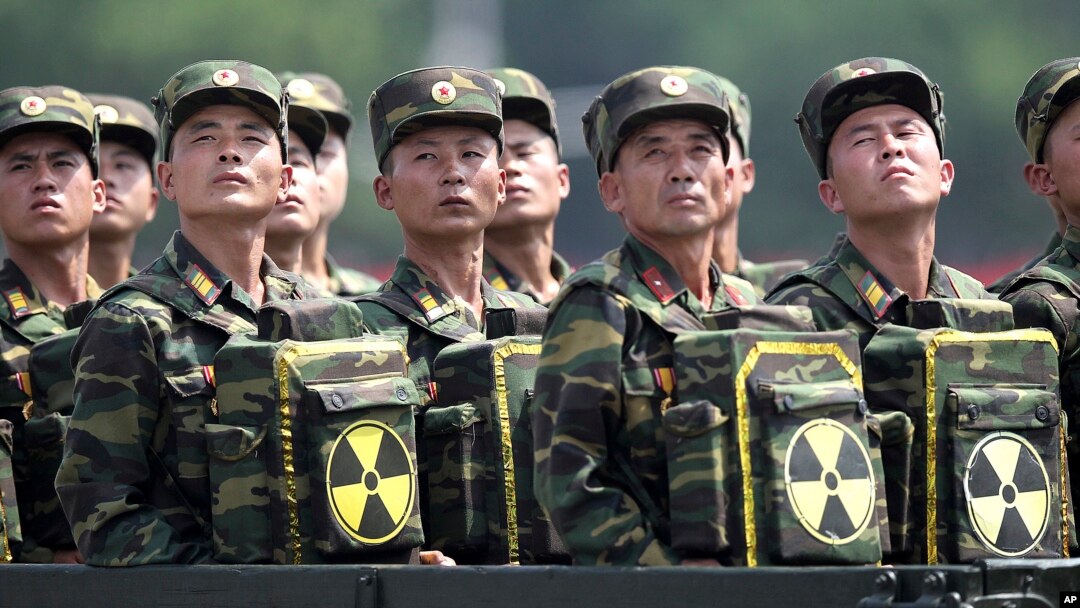 FILE - North Korean soldiers look toward their leader, Kim Jong Un, from a military parade vehicle as they carry packs marked with the nuclear symbol during a ceremony marking the 60th anniversary of the Korean War armistice in Pyongyang, North Korea, July 27, 2013.