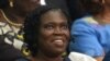 FILE - Simone Gbagbo, Ivory Coast's former first lady, smiles as she sits in the dock at the Court of Justice in Abidjan on Dec. 26, 2014, for the start of her trial.