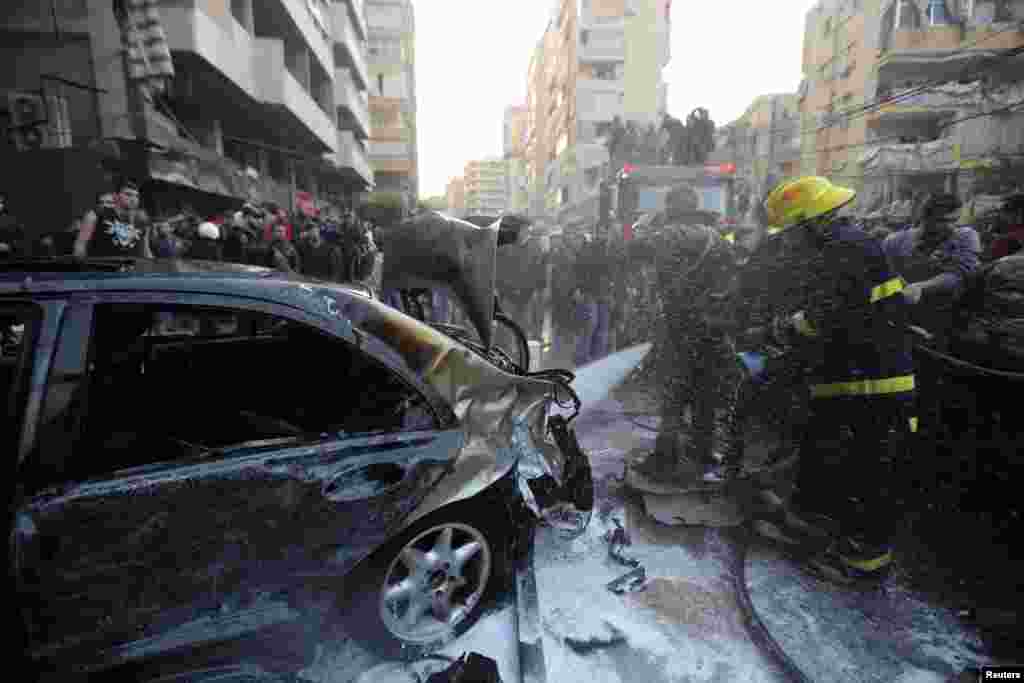 A firefighter extinguishes a fire at the site of an explosion in Beirut's southern suburbs, Jan. 2, 2014.