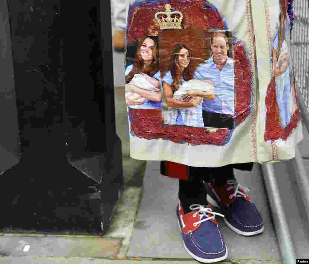 A royal fan stands outside St. James's Palace before the christening of Prince George in London, Oct. 23, 2013.