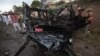 Pakistani officials and rescue workers gather at the site of a car bombing in Peshawar, Pakistan on Monday, Sept. 3, 2012.